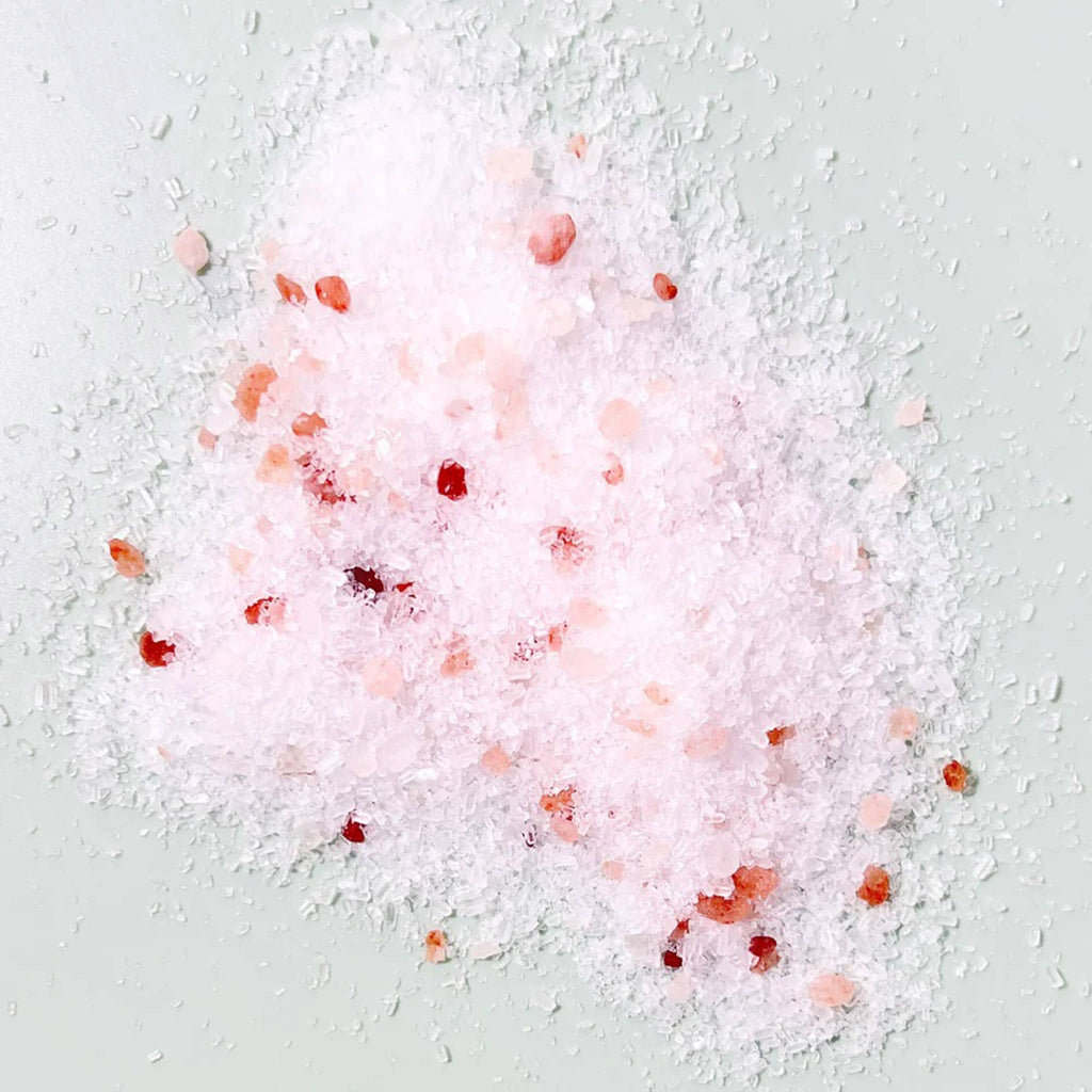 Sow the Magic Peppermint Bath Salt Soak, pile of pink tinted salts on a gray background to show color and texture.