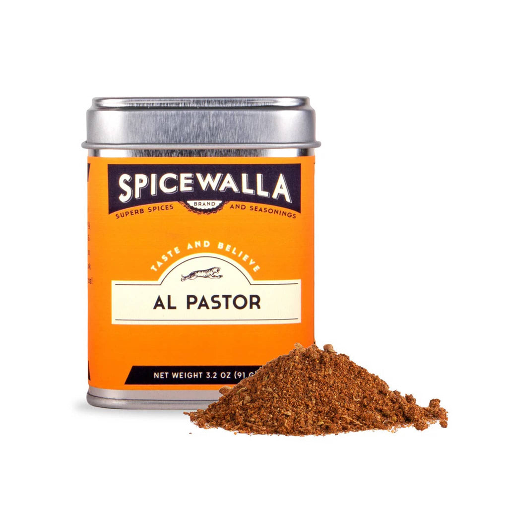 Spicewalla Al Pastor spice rub in tin with a small pile of spice on a white background.