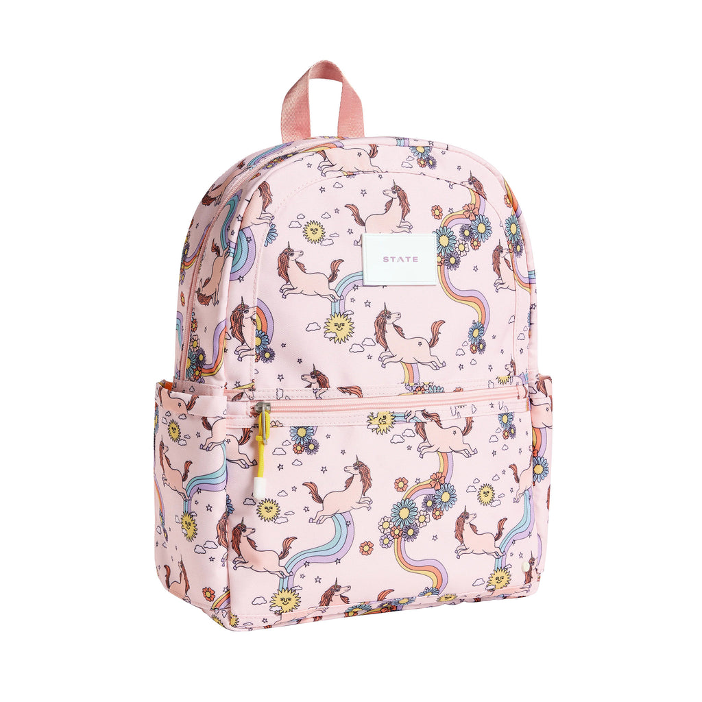 State Bags Kane Kids Recycled Poly Canvas Backpack in Unicorn with colorful pastel rainbows, flowers and unicorns on a pink background, front and side angle view.