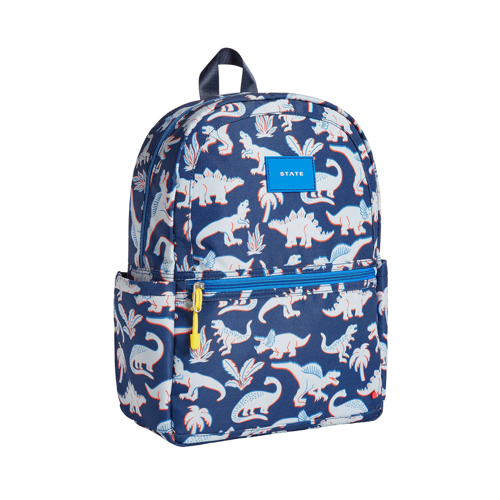 State Bags Kane Kids Recycled Poly Canvas Backpack in 3D Dinos with a red, gray and blue dinosaur print on a navy background, front and side view.