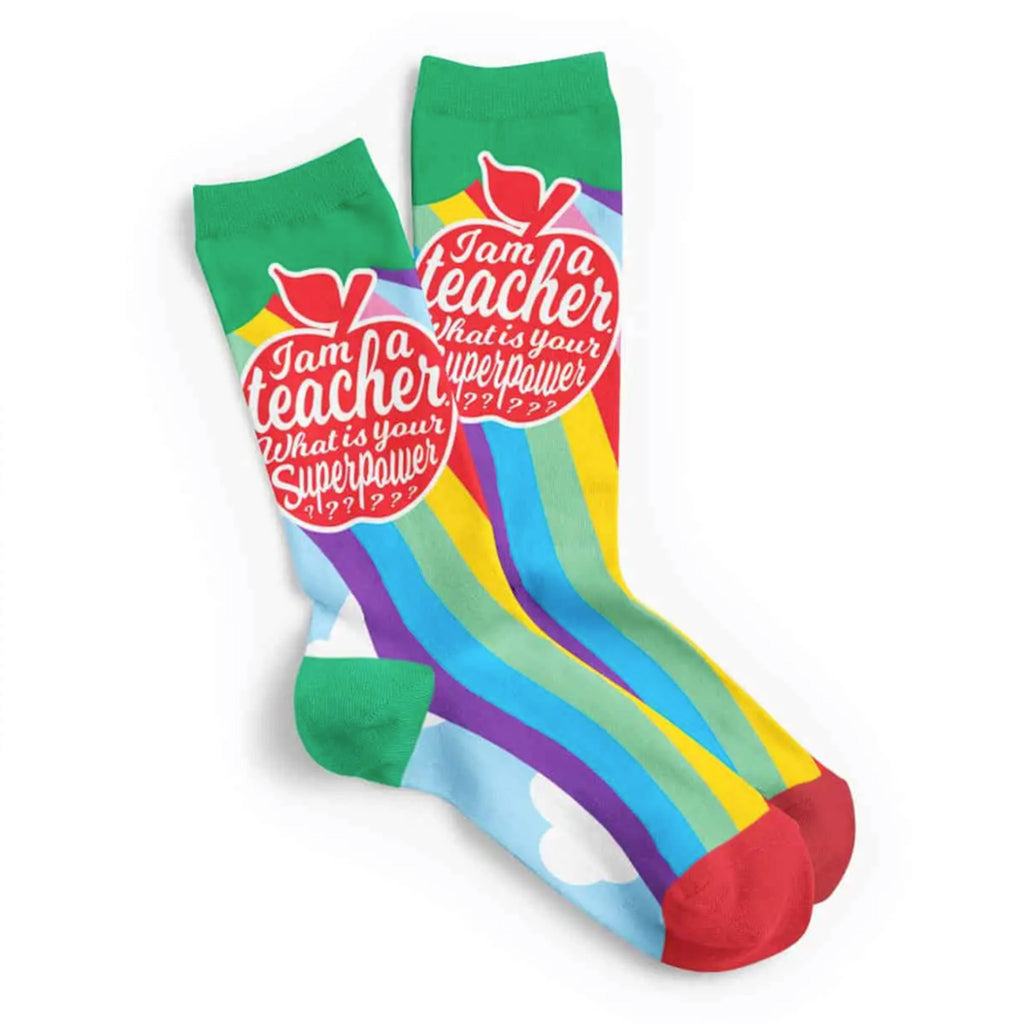 Studio Inktvis rainbow striped socks with "I am a teacher. What is your superpower" in white lettering on a red apple with a red toe and green heel and top.