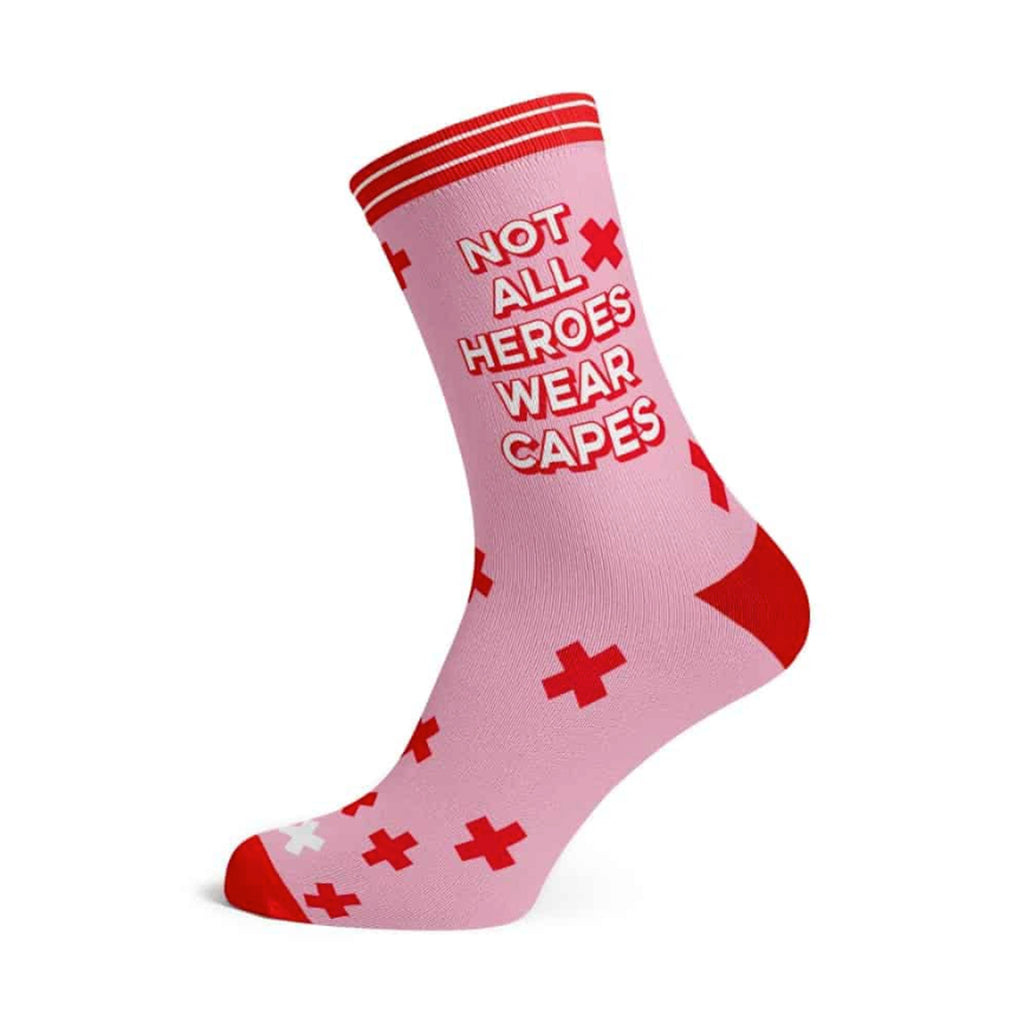 Studio Inktvis pink socks with "not all heroes wear capes" in red & white lettering with a red toe and heel and embellishments, on a foot form.