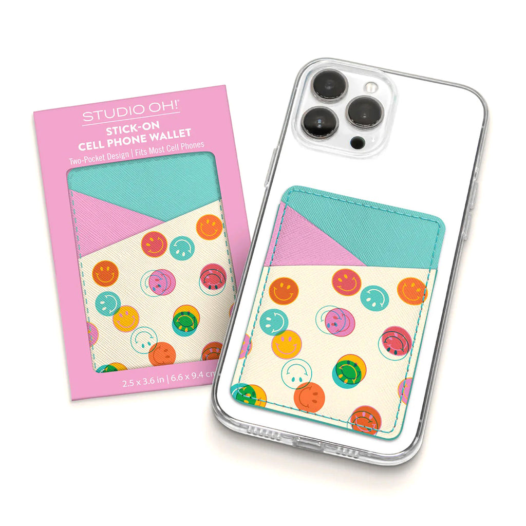 Studio Oh! Smiley Trails Stick-On Cell Phone Wallet with pink and turquoise pocket design and colorful smiley faces. Shown in packaging and attached to the back of a phone.