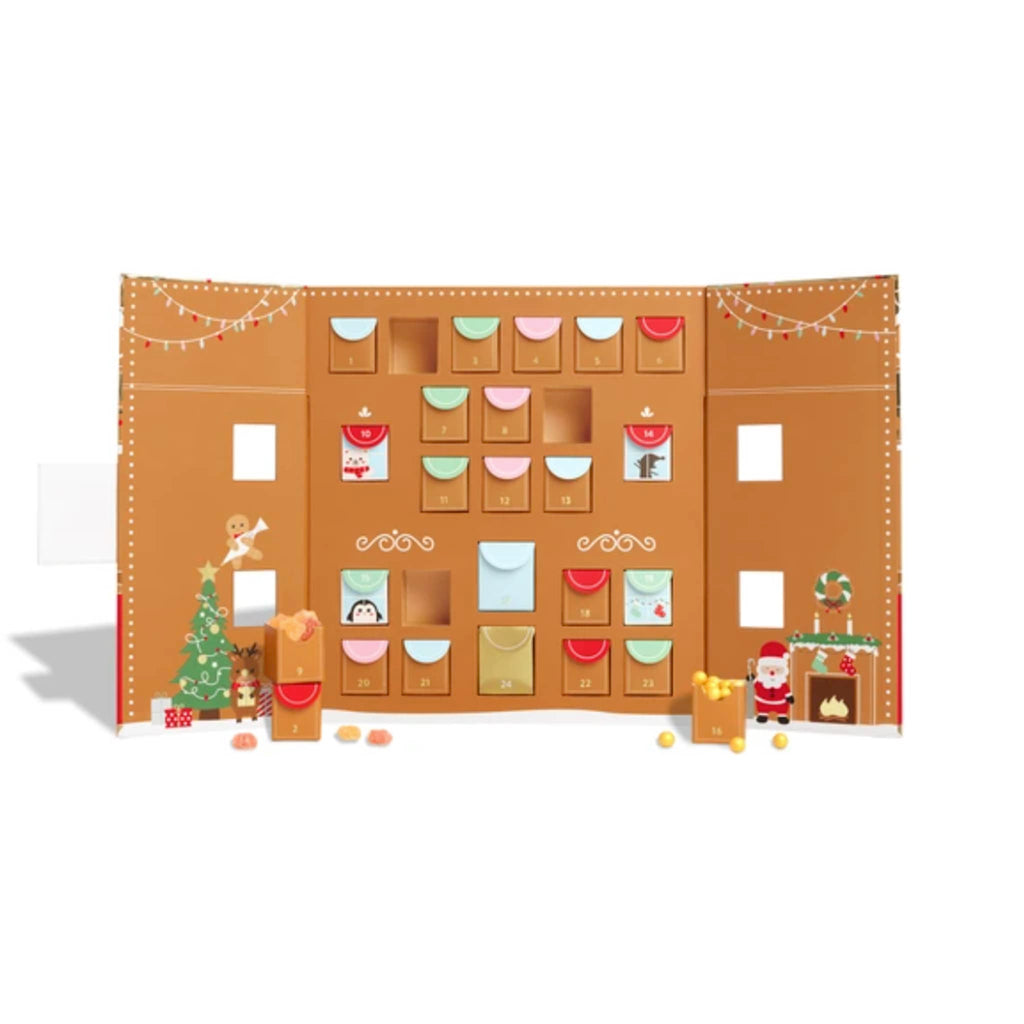 Sugarfina 24 Tastes of Christmas Gingerbread House shaped candy advent calendar, open to show inside with drawers of candy.