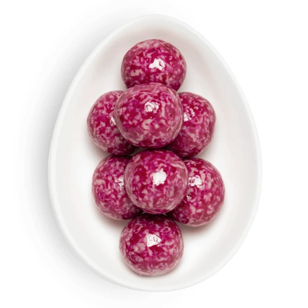 Pink speckled balls on a white oval plate with a white background.