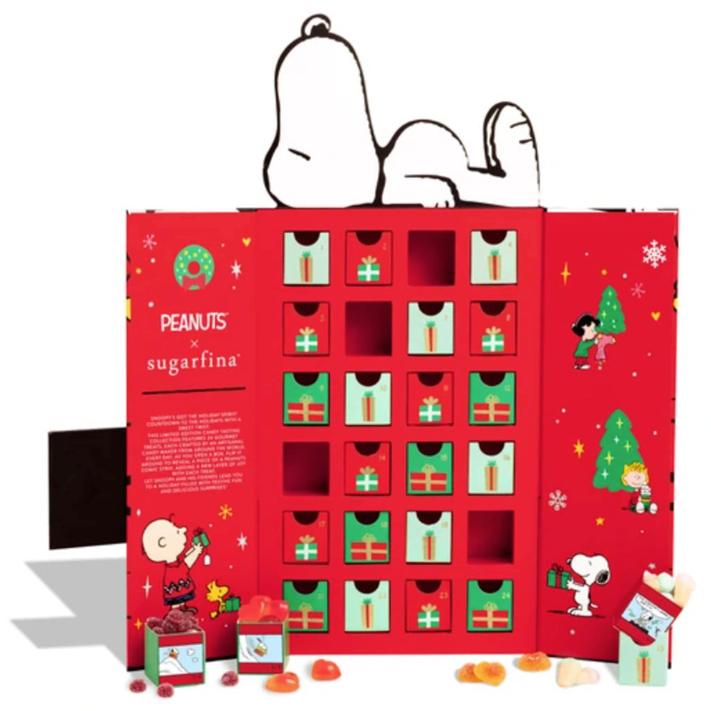 Red advent calendar with Peanuts and Sugarfina branding, featuring cartoon characters and drawers of candy, on a white background.