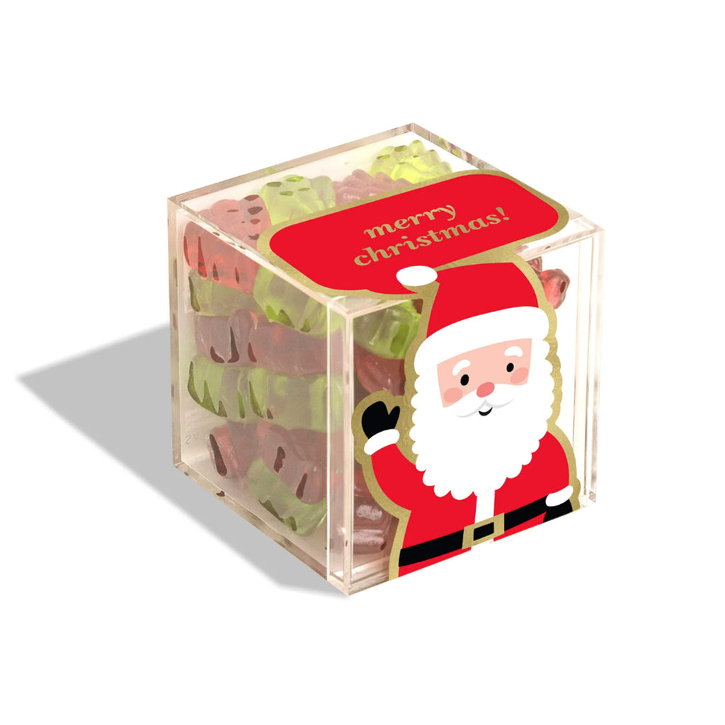 Sugarfina Santa's Trees red and green tree shaped holiday gummies in small clear acrylic candy cube with a waving Santa on front and "merry christmas" in gold lettering on a red background on top.