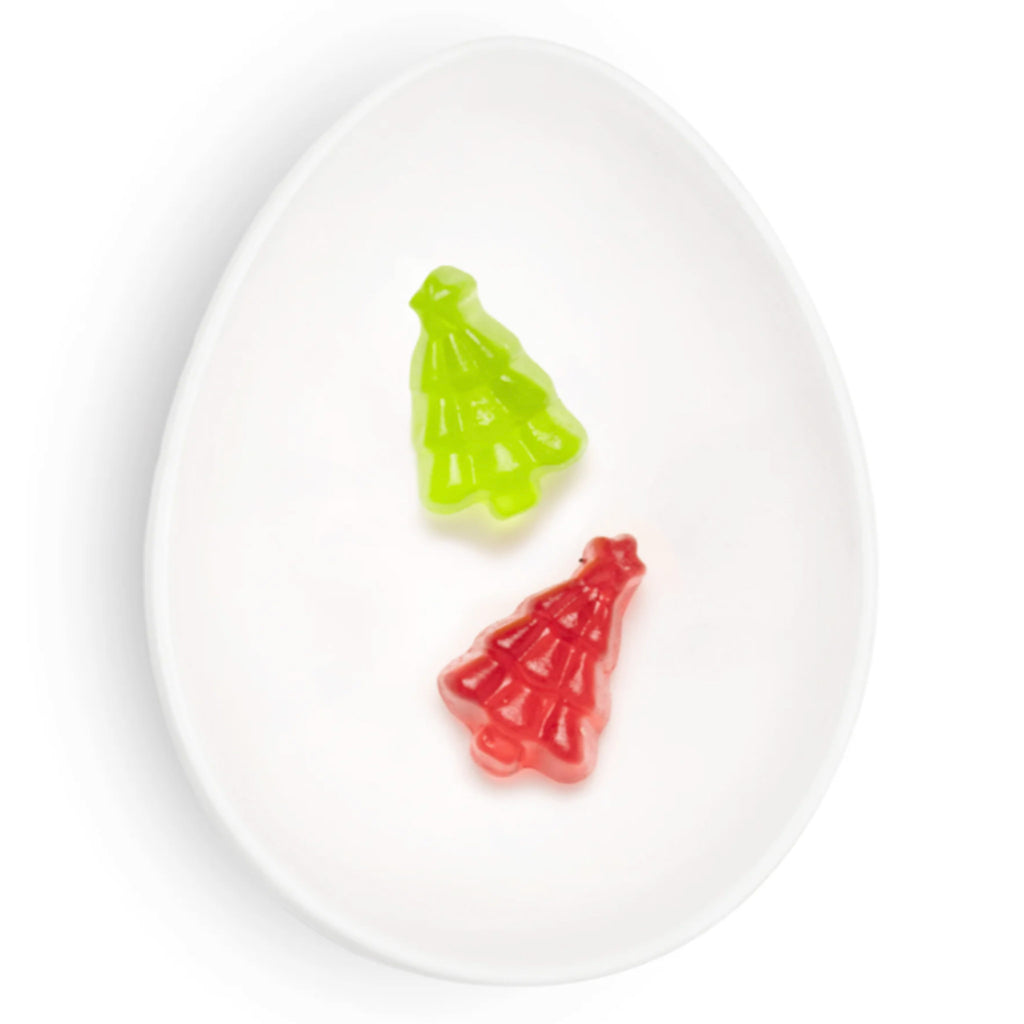 Sugarfina Santa's Trees red and green tree shaped holiday gummies in a white oval dish.