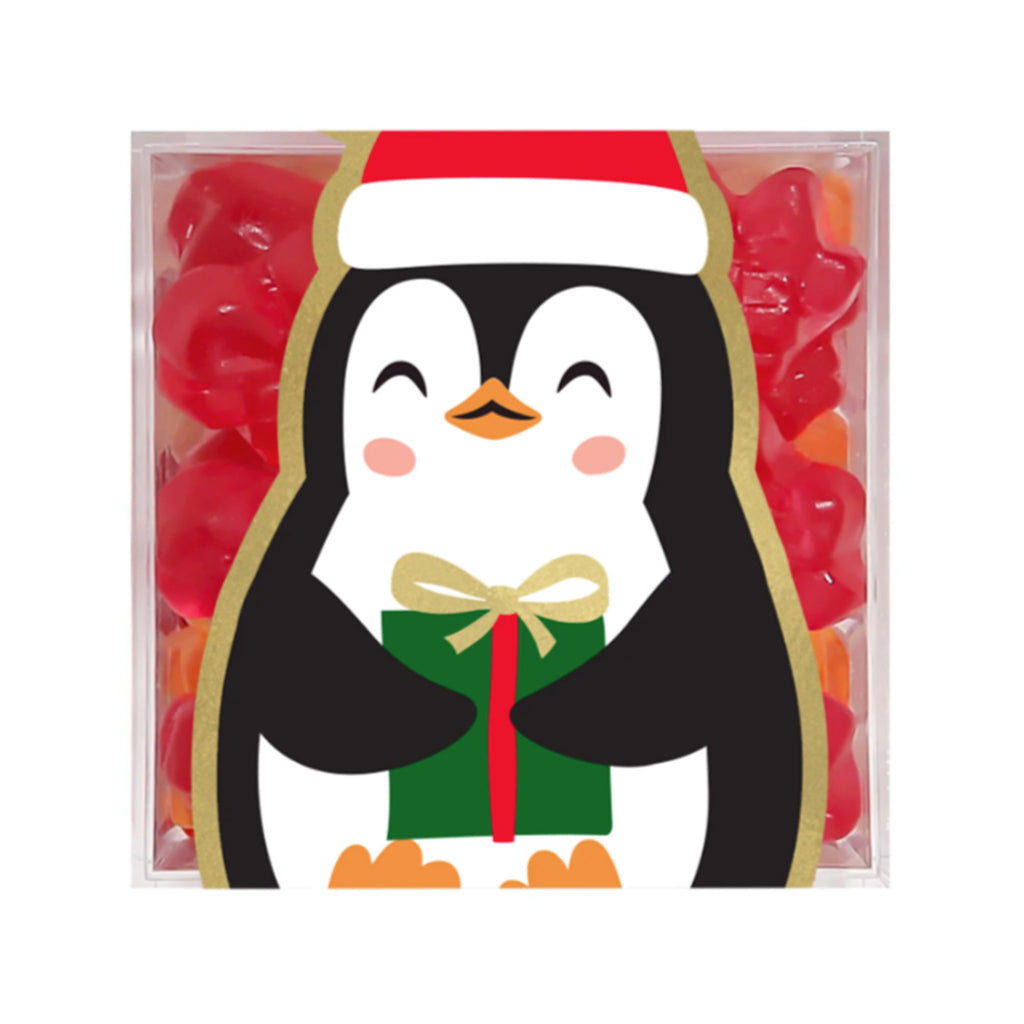 Sugarfina Penguin Presents holiday gummy candy in small clear acrylic candy cube with a penguin holding a gift on the front.
