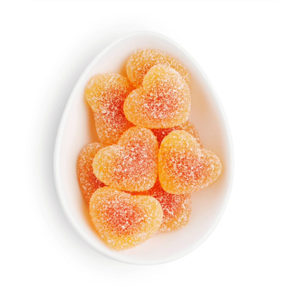 Sugarfina La Vie en Rose Collection Peach Bellini heart shaped gummies in white oval dish.