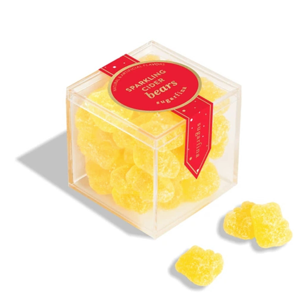 Clear cube container with yellow gummy bears and a red label on a white background.