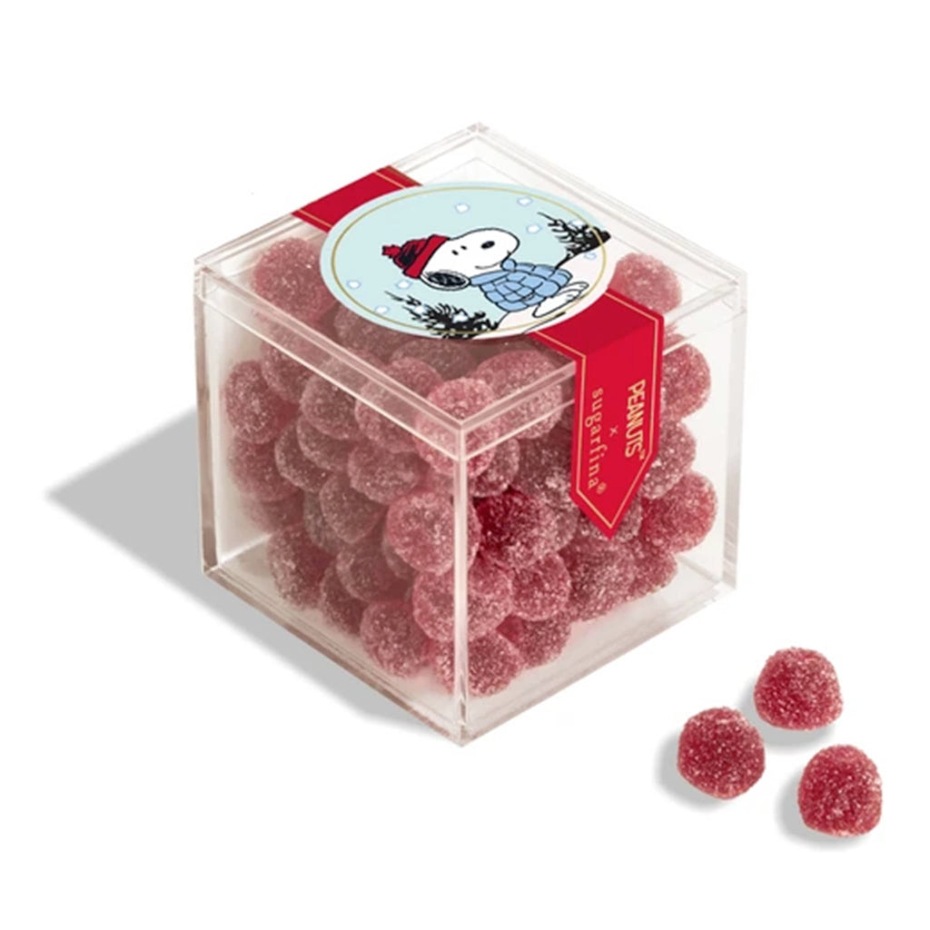 Clear cube container filled with red gummy candies, featuring a label with Snoopy, on a white background.