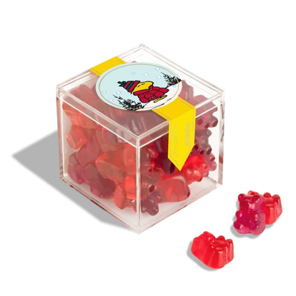 Clear cube container with Woodstock sticker, filled with red gummy bears on a white background.