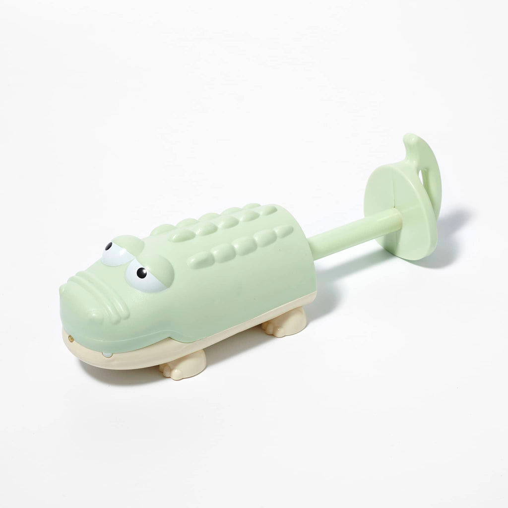 Sunnylife Crocodile Water Squirter in pastel green overhead front and side view, handle extended.