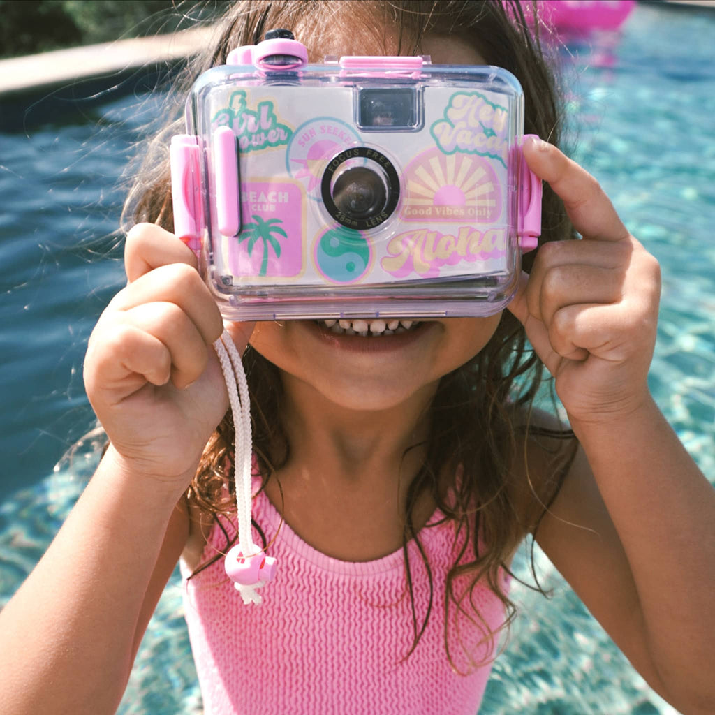 Sunnylife Summer Sherbet 35mm waterproof underwater camera with green, yellow, pink and blue illustrations on a white background, with child in a pool taking a picture.