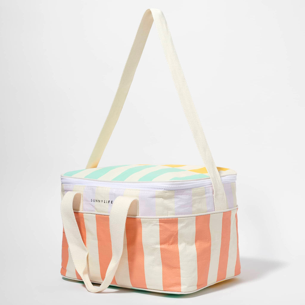 Sunnylife Cooler Bag in Rio Sun with blue, yellow, lilac, orange and cream maxi stripes, front and side view, closed with shoulder strap up.