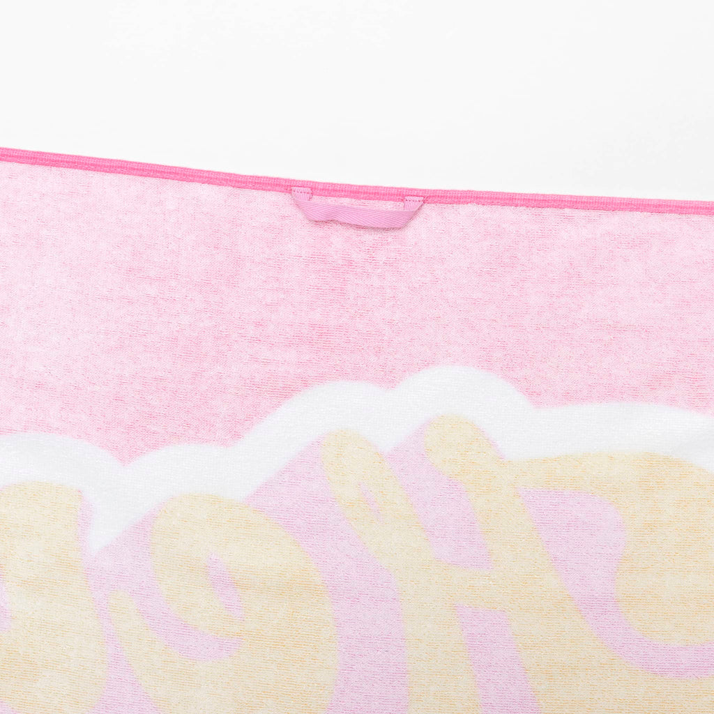 Sunnylife summer sherbet kids beach towel in bubblegum pink with "hey vacay" in yellow lettering, back detail.