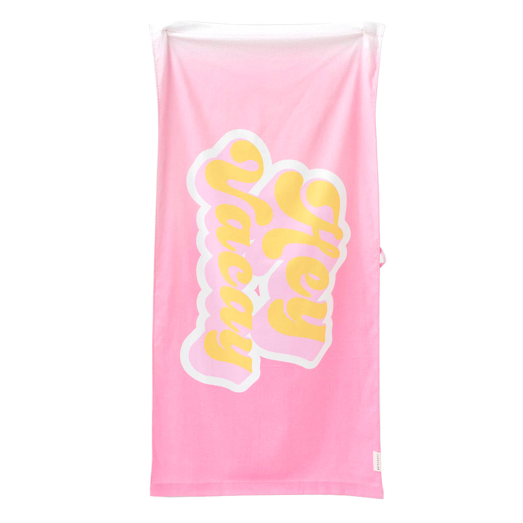 Sunnylife summer sherbet kids beach towel in bubblegum pink with "hey vacay" in yellow lettering, flat view.