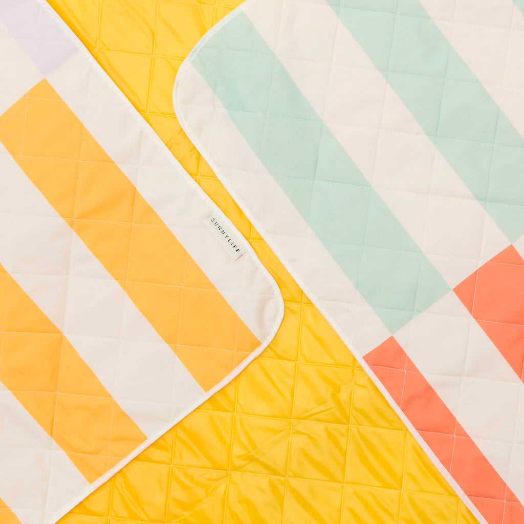 Sunnylife Beach and Picnic Blanket in Rio Sun with colorful stripes with solid yellow quilted backing.