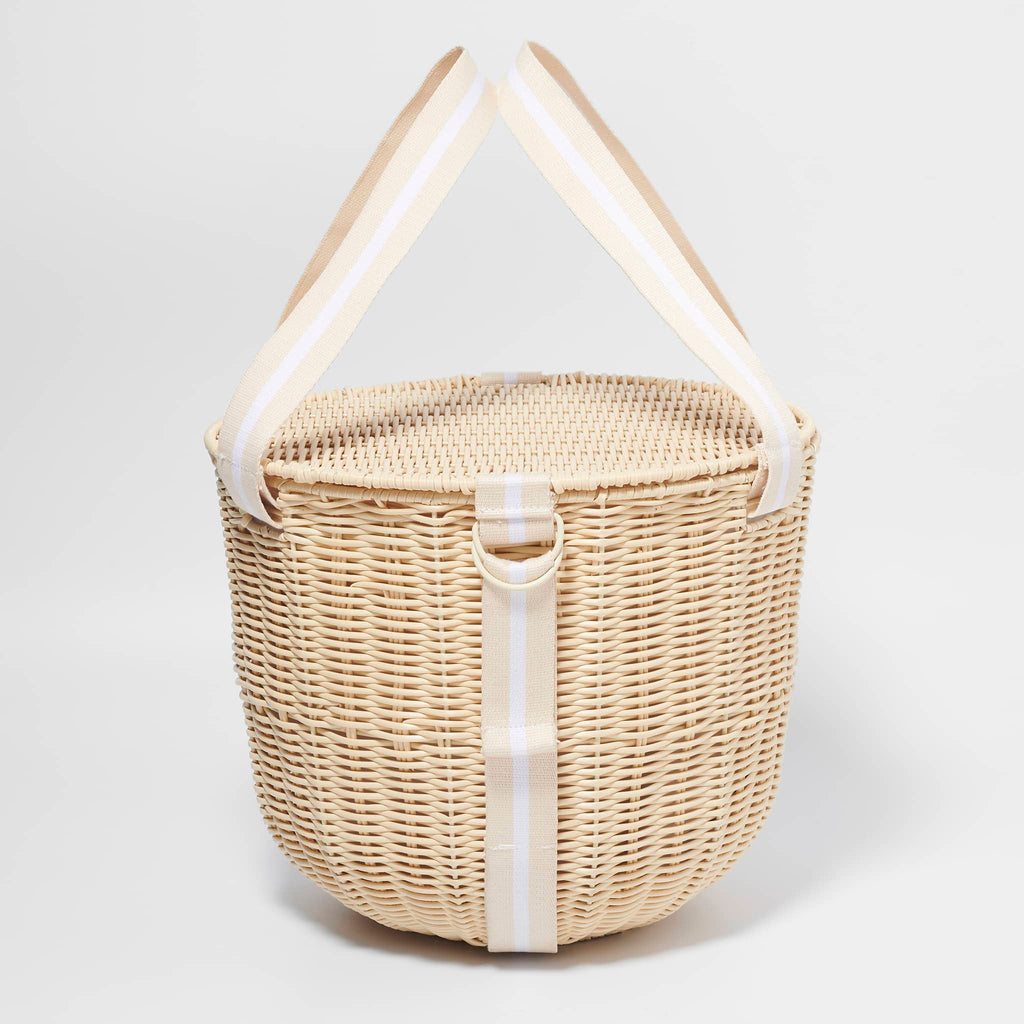 Sunnylife Round Plastic Rattan Insulated Picnic Cooler Basket in Le Weekend with natural and white webbed straps, side view with straps up.