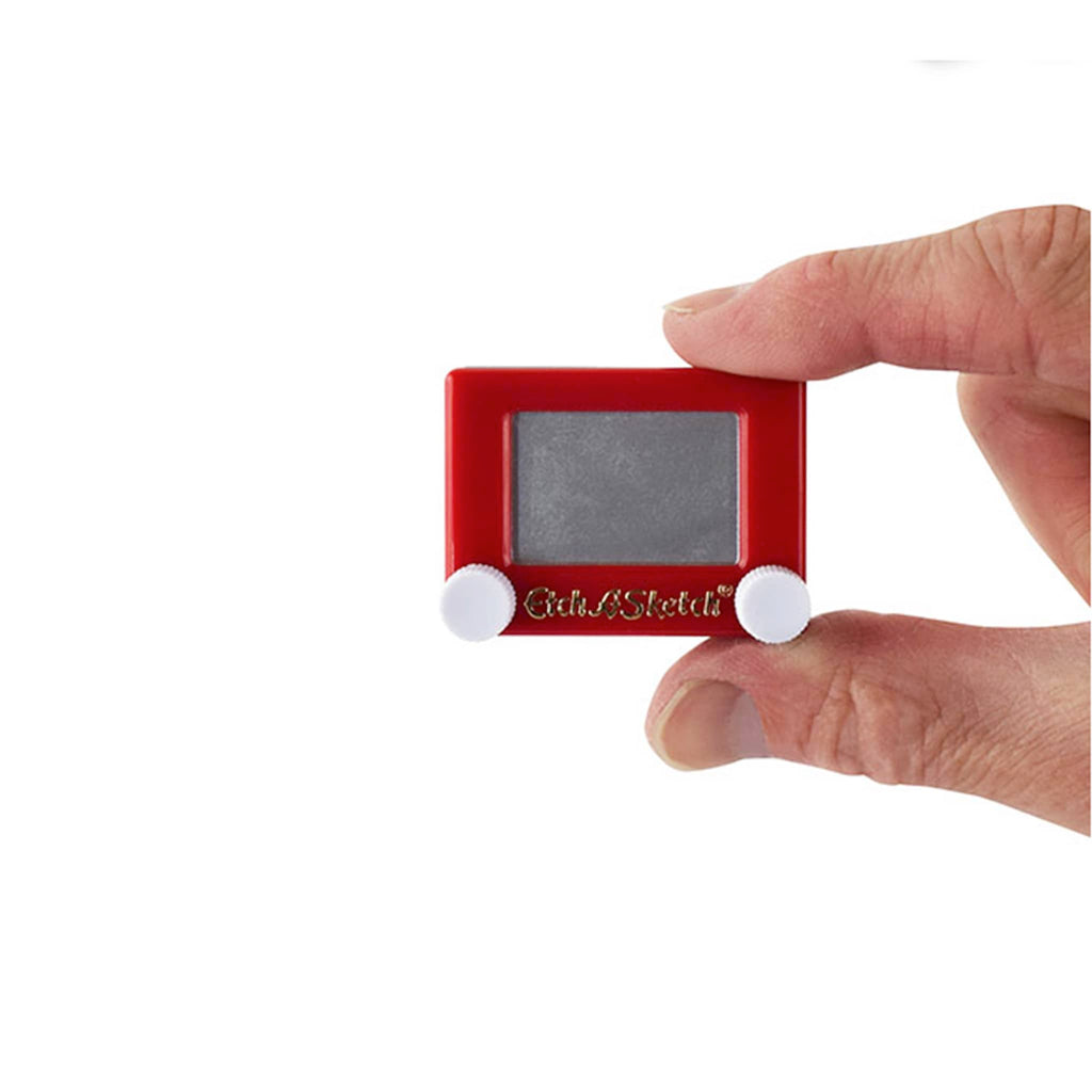 Mini Etch a Sketch being held against a white background.