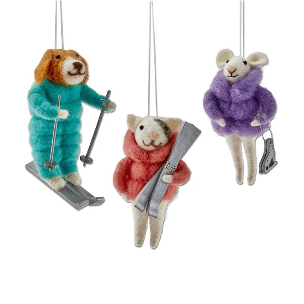 Three felt animal ornaments dressed in winter clothing and skiing or ice skating equipment on a white background.