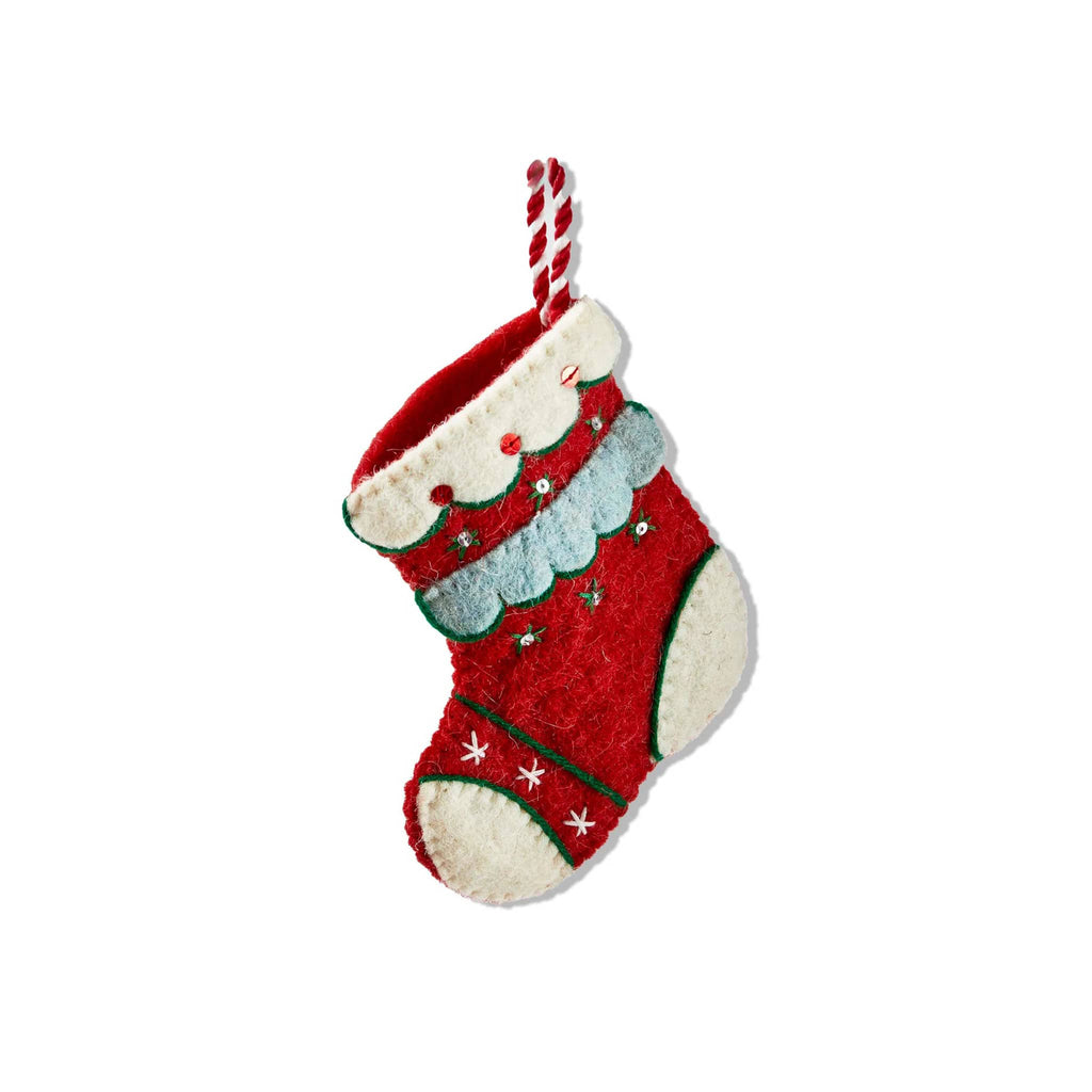 Red Christmas stocking with sequin and stitched details on a white background.