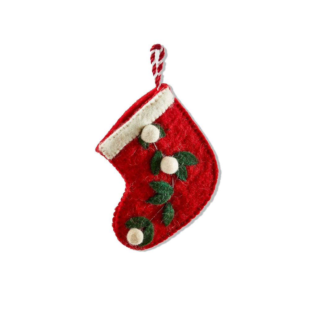 Mini red Christmas stocking with white trim and berries and green holly leaves on a white background.