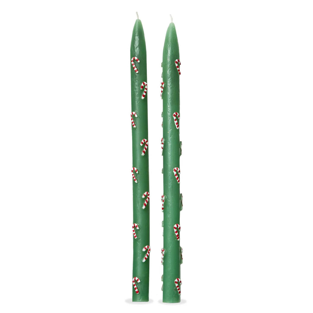 Two green taper candles with candy canes on a white background.
