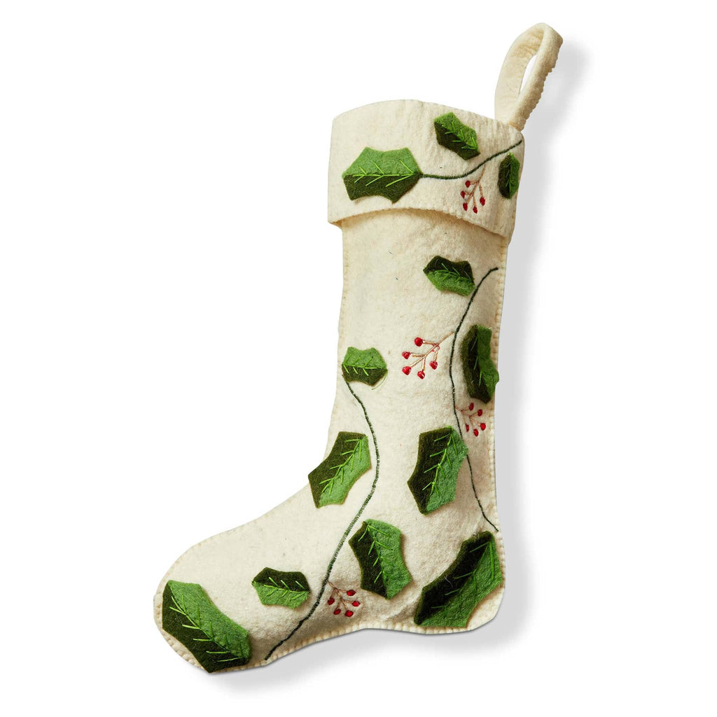 Decorative white felt Christmas stocking with green holly leaf and red berry patterns on a white background.