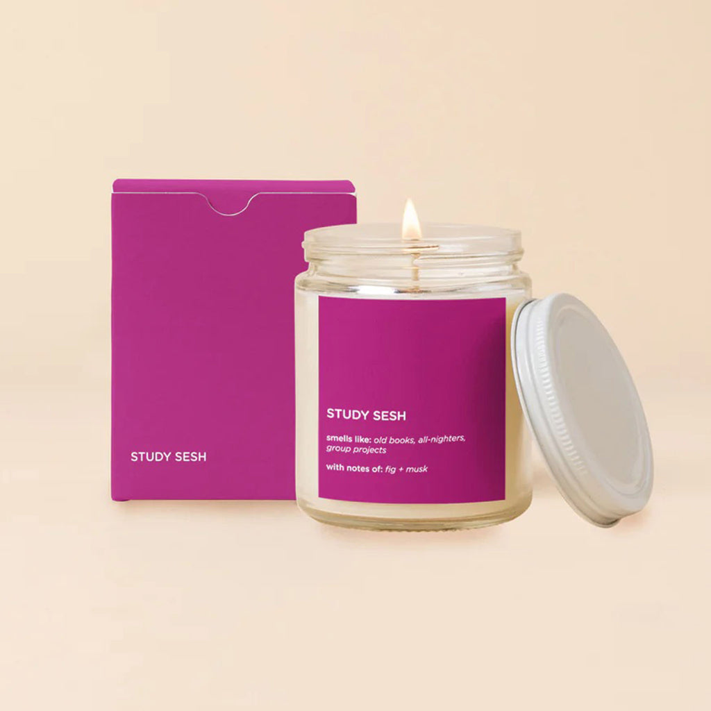 Talking out of turn study sesh scented soy wax candle in clear jar with white metal lid and fuchsia label and matching gift box.