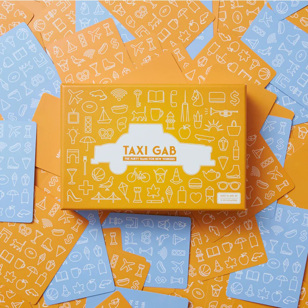 Taxi Gab: The Party Game for New Yorkers in illustrated yellow box packaging lying on a pile of included yellow and blue cards.