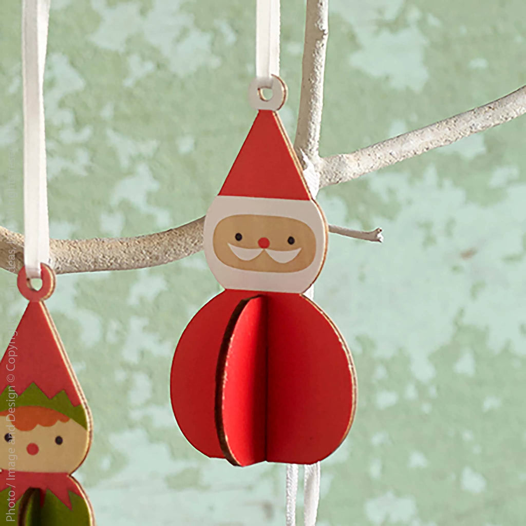 Red Santa Claus wood ornament hanging on a branch with a light green background.