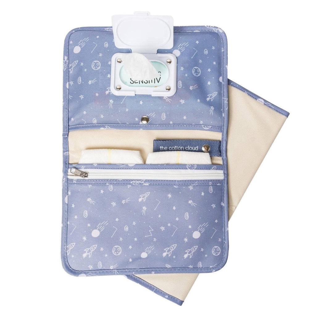 The Cotton Cloud Diaper Clutch Bag and Changing Pad with cosmic space-themed print on blue backdrop, opened showing features inside.