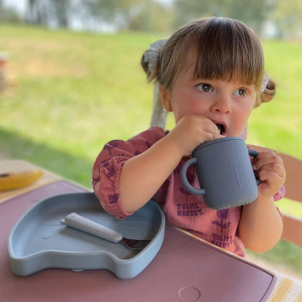 The Cotton Cloud Lili Sippy Cup in  indigo with child.