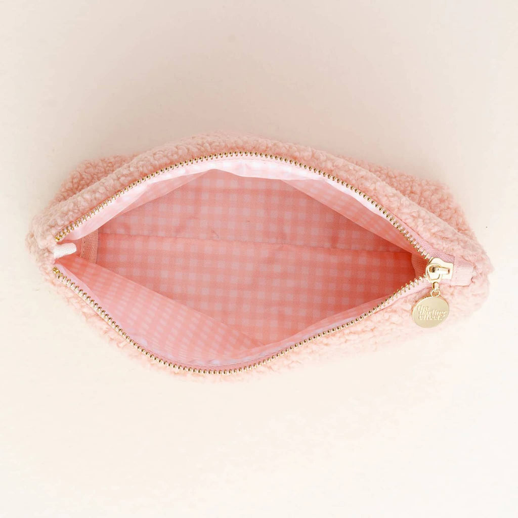 The Darling Effect teddy sherpa zip pouch in pink with red hearts, overhead view showing pink and white gingham wipeable lining inside.