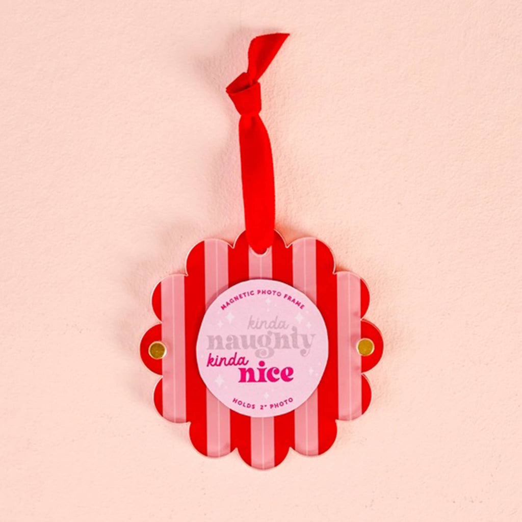 Red and pink striped round magnetic photo frame with scalloped edge and a red ribbon on a pink background.