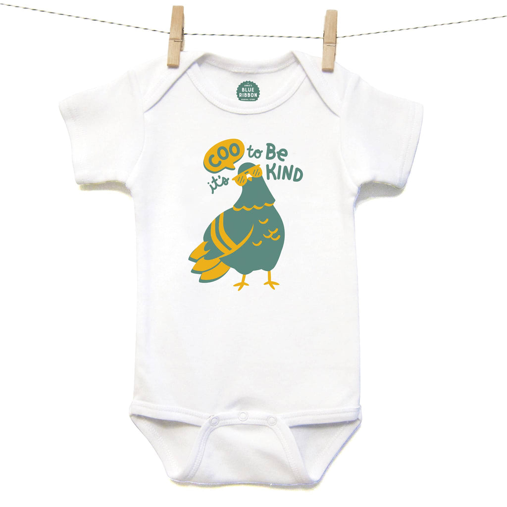 The Neighborgoods It's Coo to be Kind baby one-piece with a green and yellow pigeon with sunglasses illustration on a white background.