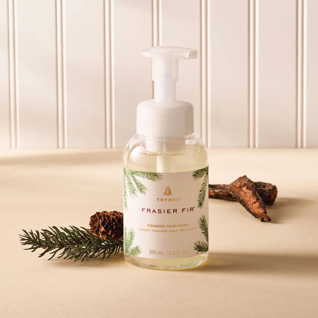Frasier Fir hand wash bottle with pump on a beige surface with tree branch and tree bark.