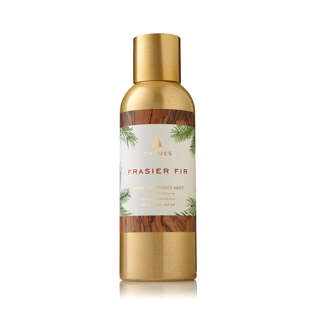 Thymes Frasier Fir scented home fragrance mist in gold bottle with label featuring a pine needle print.