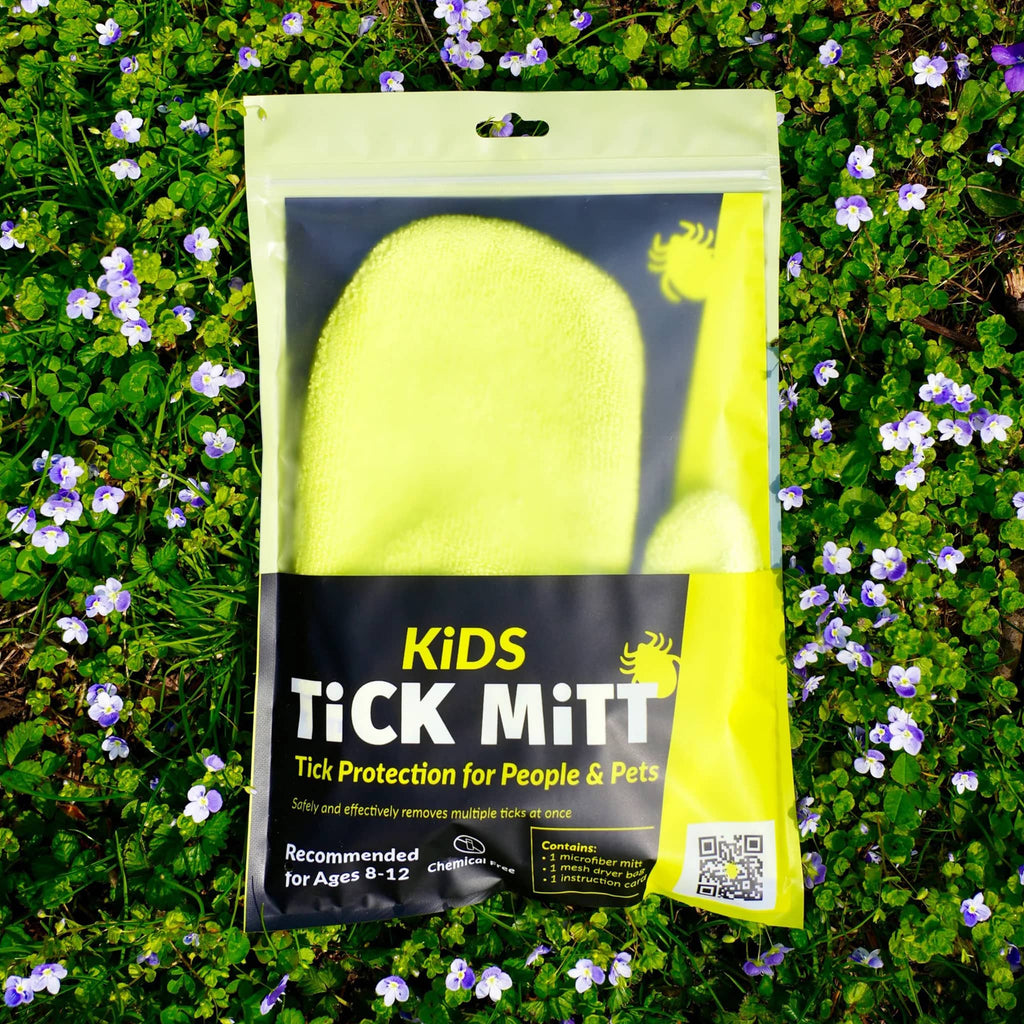 Kids Tick Mitt in yellow, in pouch packaging on grass.