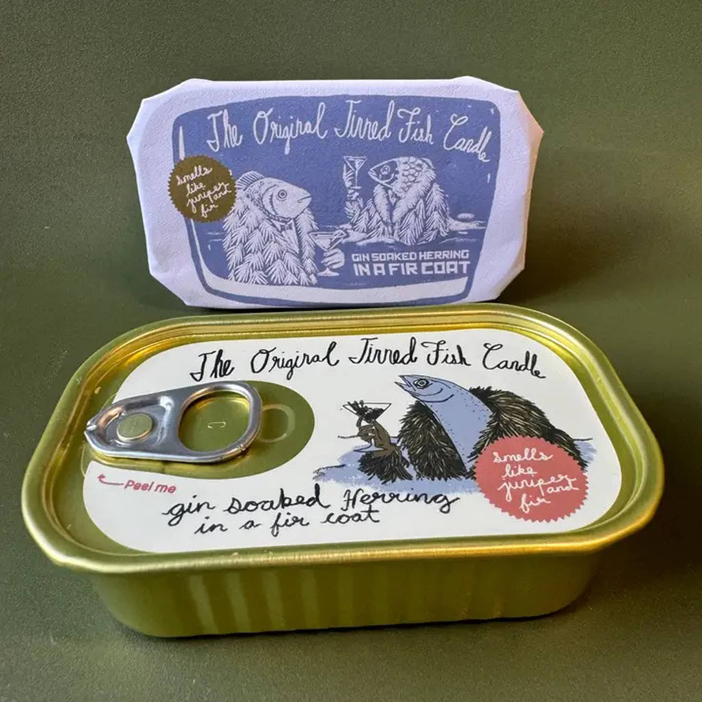 The Original Tinned Fish Candle Juniper and Fir scented holiday soy wax candle in sardine tin packaging, wrapped in paper and unwrapped.