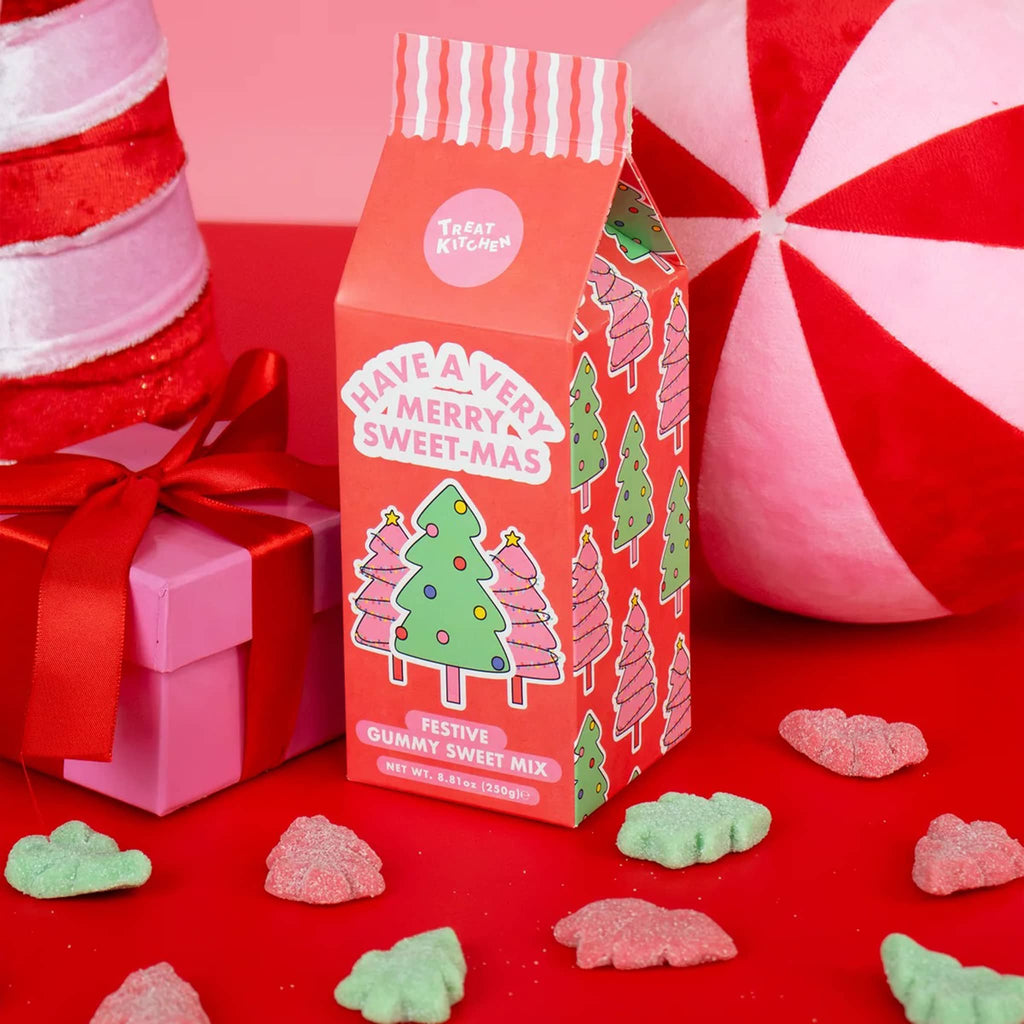 Red candy box with Christmas tree design on a red background with candy and gift.