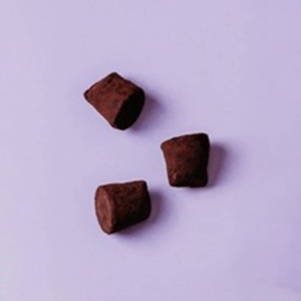 Tuck's Classic French Chocolate Truffles, three pieces on a purple background.