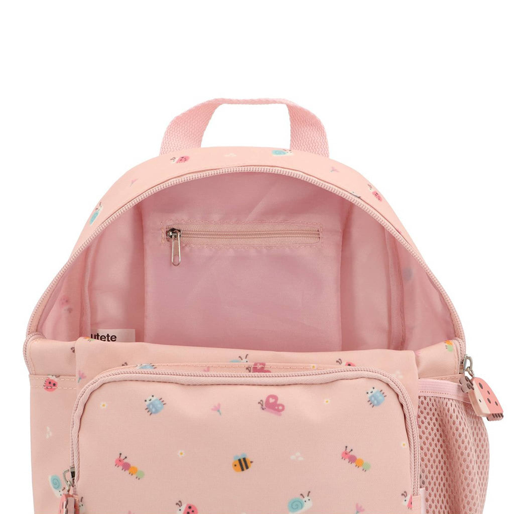 Pink backpack with small bug illustrations, front view, unzipped to show interior zip pocket, on a white background.