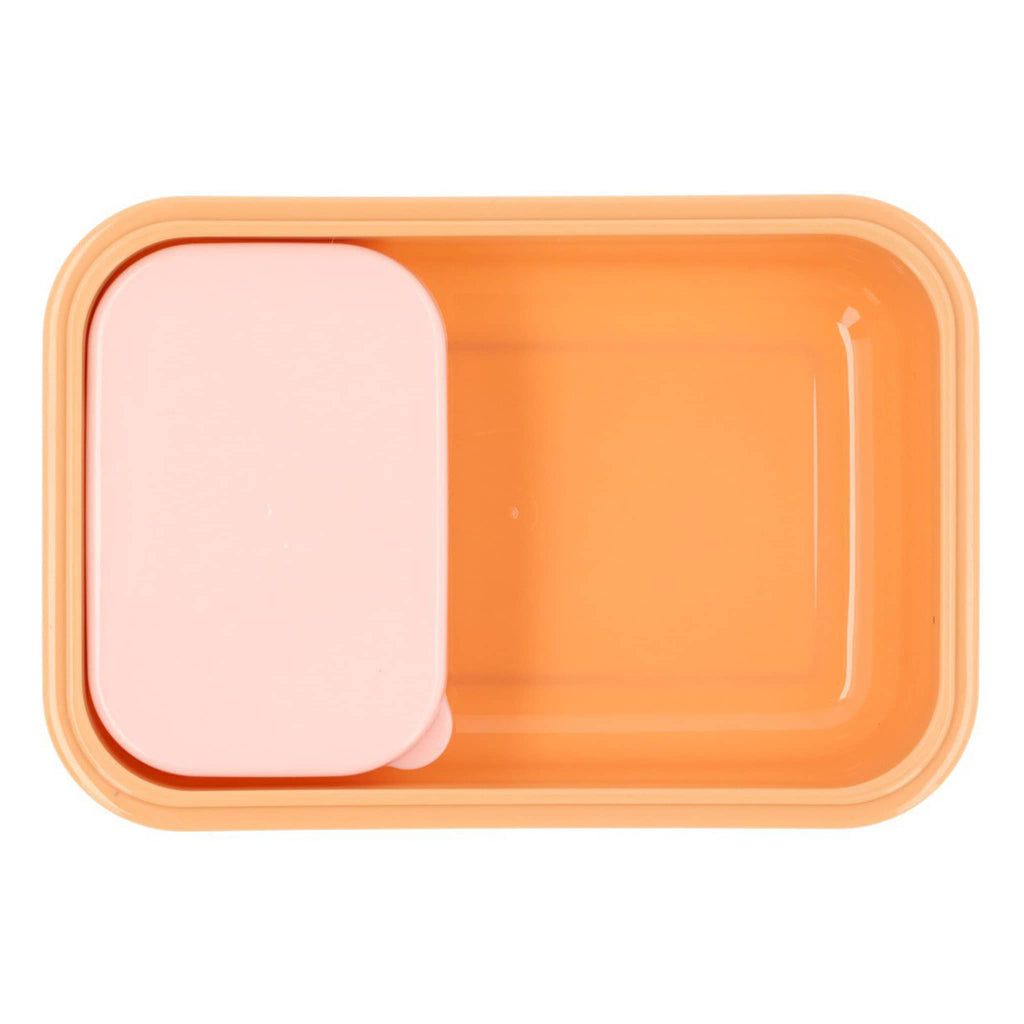 Pink and beige kids bento lunch box, smaller box with lid nestled inside larger outer box with orange interior, overhead on a white background.