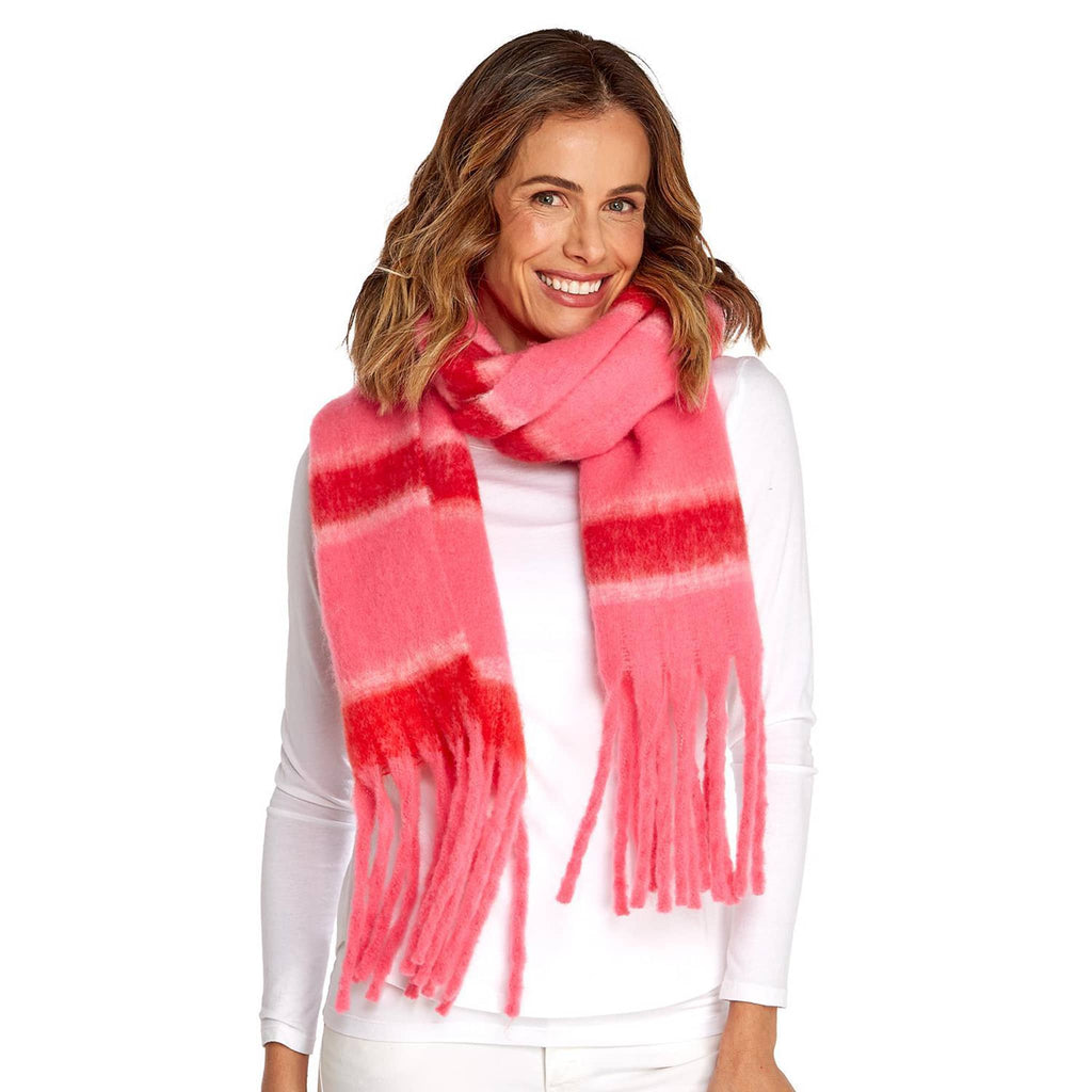 Two's Company red and pink striped winter scarf with fringe, shown on model.