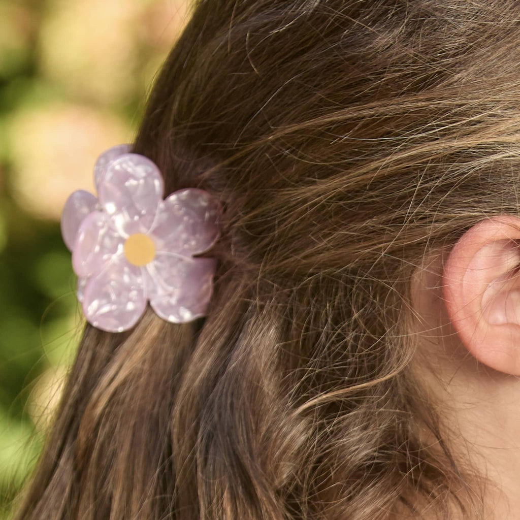 Two's Company Happy Days claw hair clip in flower designs, in child's hair.