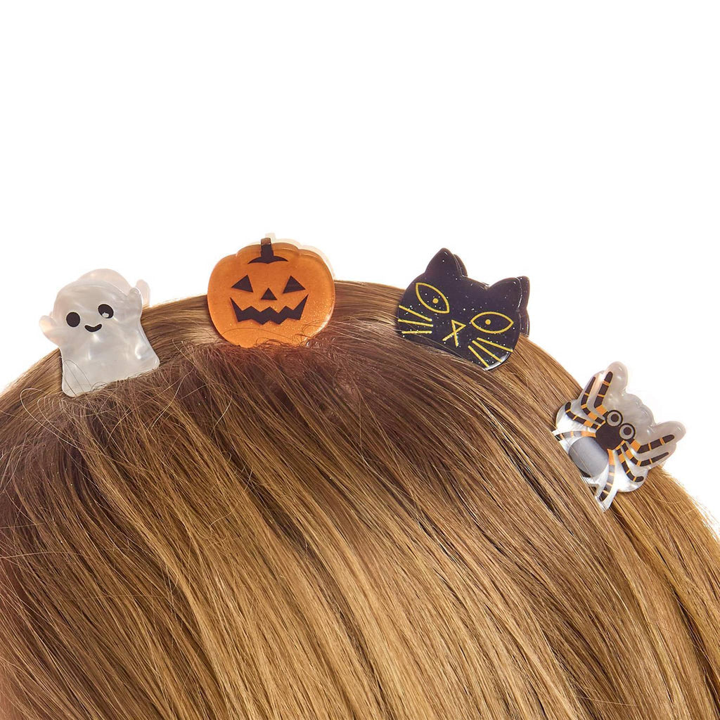 Halloween-themed hair clips on a person's head with a white background.