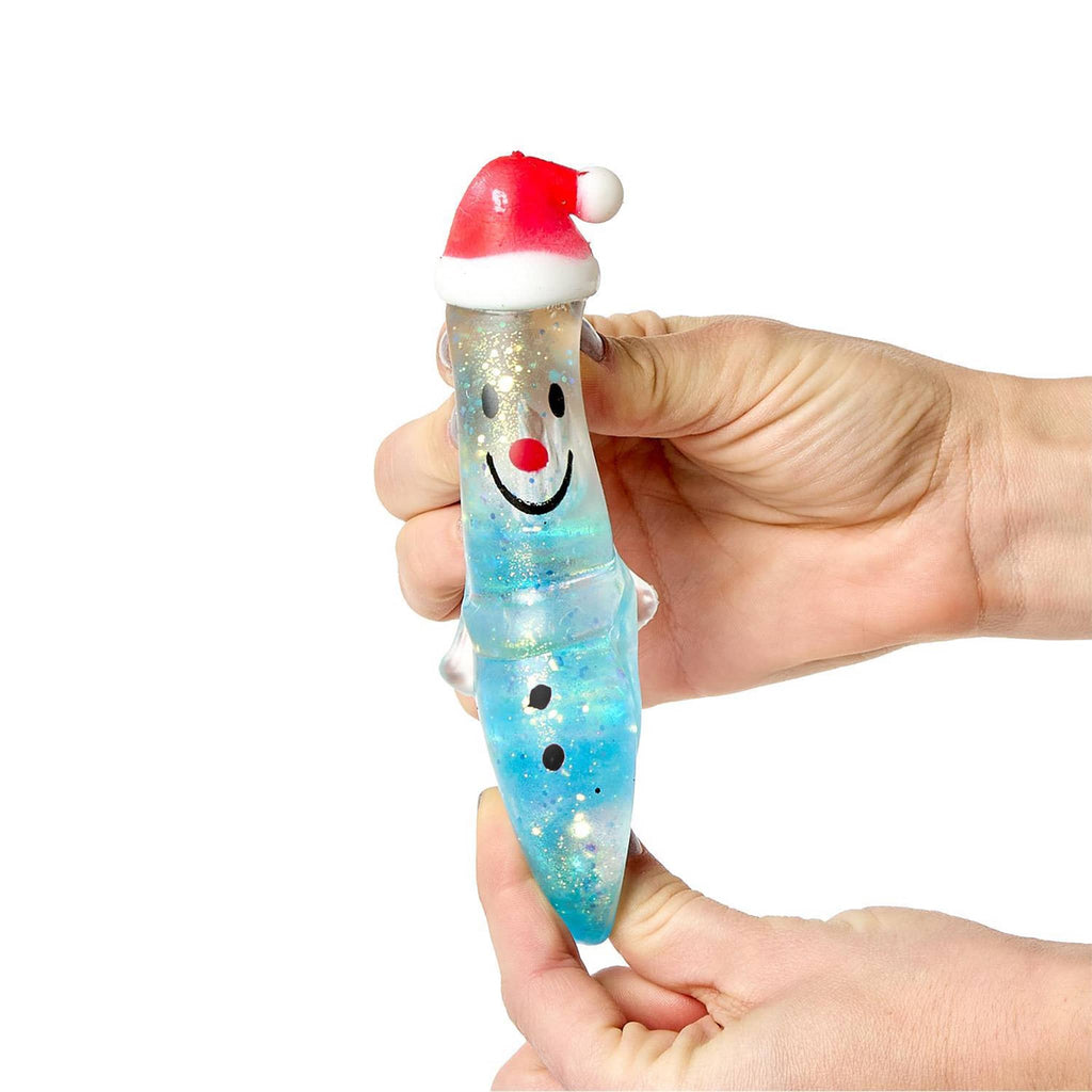 Hand holding a blue snowman squish toy with a Santa hat and red nose on a white background.